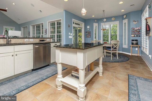 kitchen with dishwasher, dark stone counters, a kitchen breakfast bar, decorative light fixtures, and white cabinetry