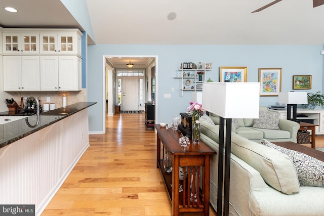 living room featuring ceiling fan, light hardwood / wood-style floors, and sink