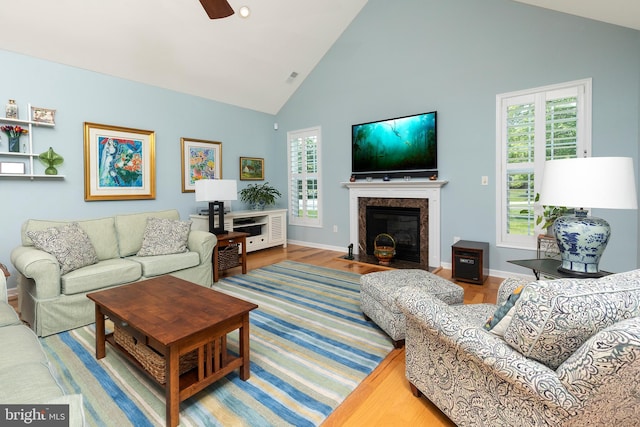 living room with wood-type flooring, high vaulted ceiling, plenty of natural light, and ceiling fan