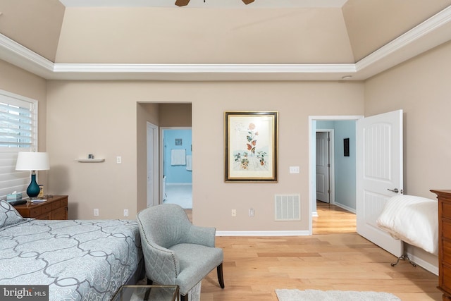 bedroom featuring ceiling fan, lofted ceiling, a tray ceiling, and light hardwood / wood-style flooring