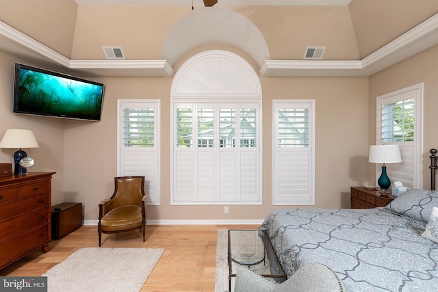 bedroom with light hardwood / wood-style floors, vaulted ceiling, and ornamental molding