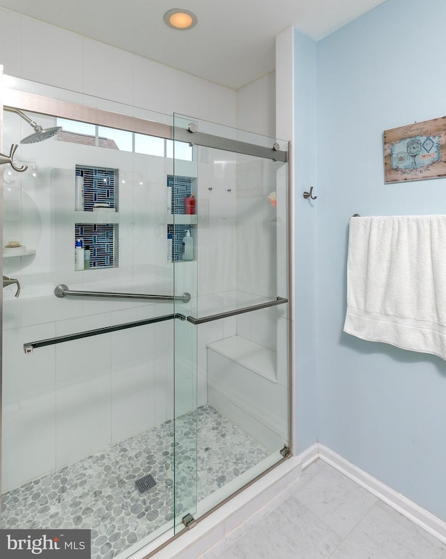 bathroom featuring a shower with shower door