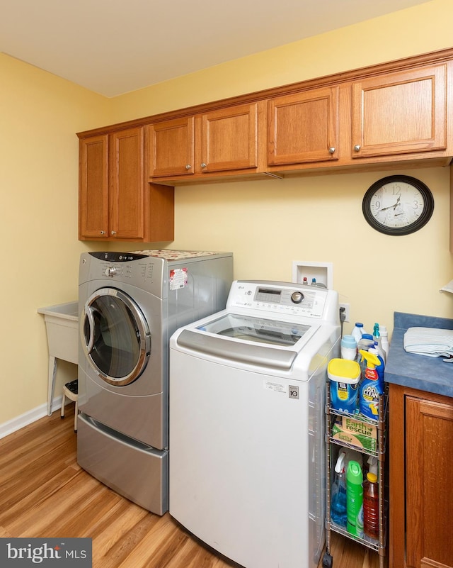 washroom featuring washing machine and dryer and light hardwood / wood-style floors