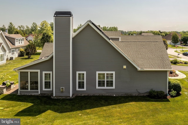 rear view of house featuring a lawn