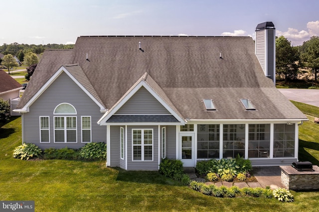 back of property featuring a sunroom and a lawn