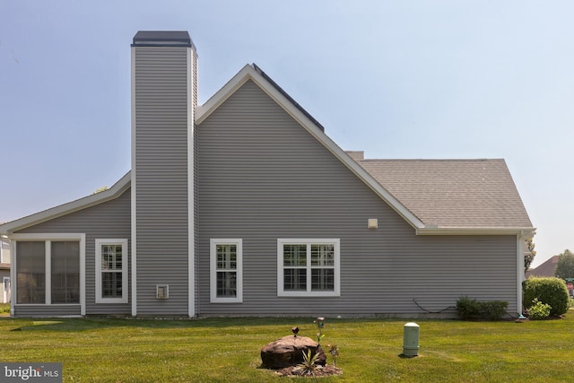 rear view of property with a yard