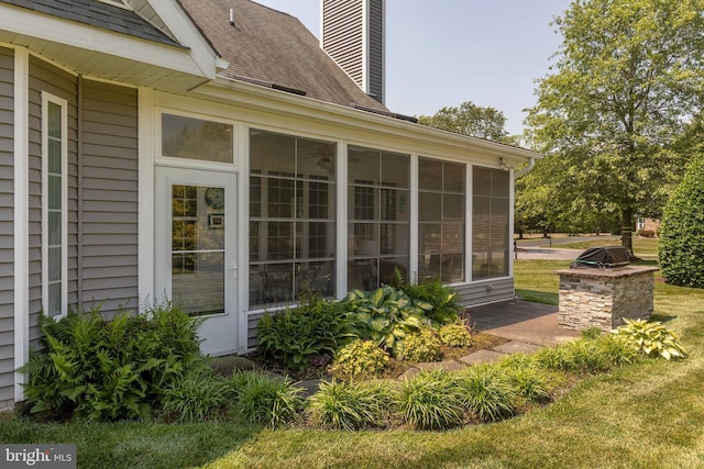 view of side of property with a lawn and a sunroom