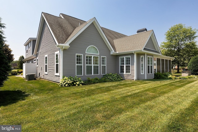 back of house with a sunroom, central AC unit, and a lawn