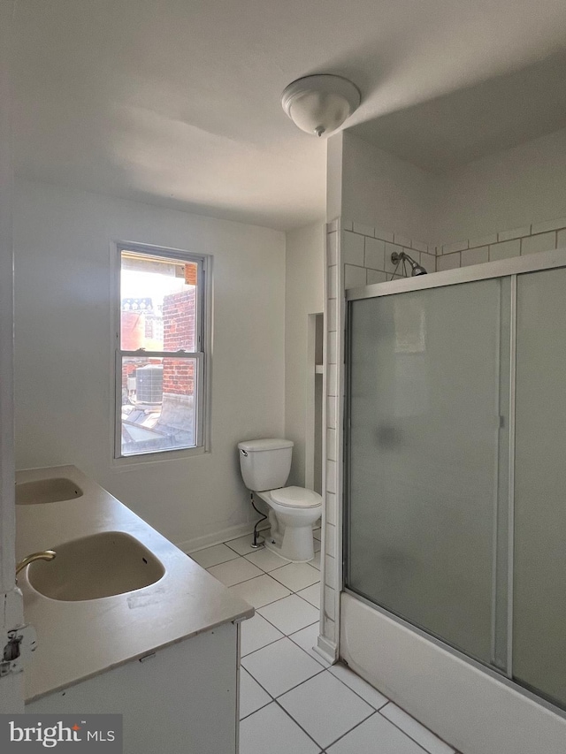 full bathroom featuring toilet, bath / shower combo with glass door, tile patterned floors, and vanity