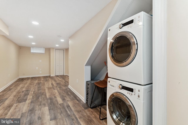 laundry area with hardwood / wood-style flooring and stacked washer / dryer