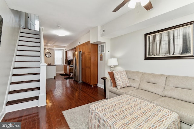 living room with ceiling fan and dark wood-type flooring