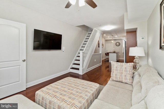 living room featuring ceiling fan and dark wood-type flooring