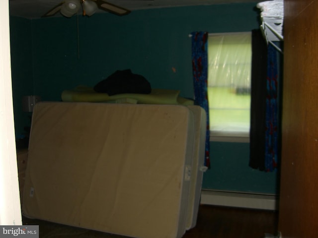 bedroom featuring ceiling fan and a baseboard heating unit