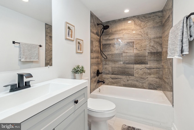 full bathroom with tile patterned floors, vanity, tiled shower / bath combo, and toilet