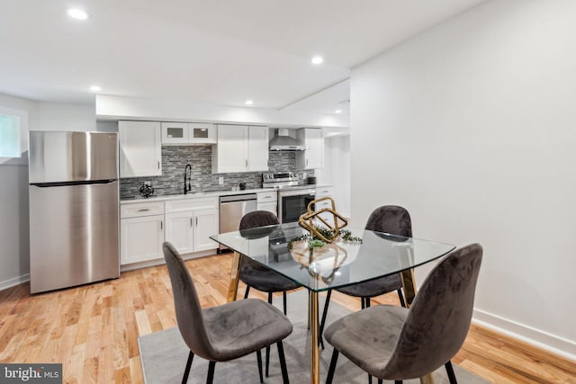 dining area with light wood-type flooring and sink