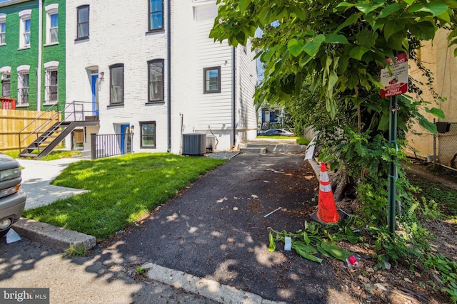 view of side of home with a lawn and central AC unit