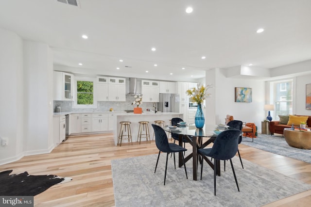 dining space with light hardwood / wood-style floors and sink