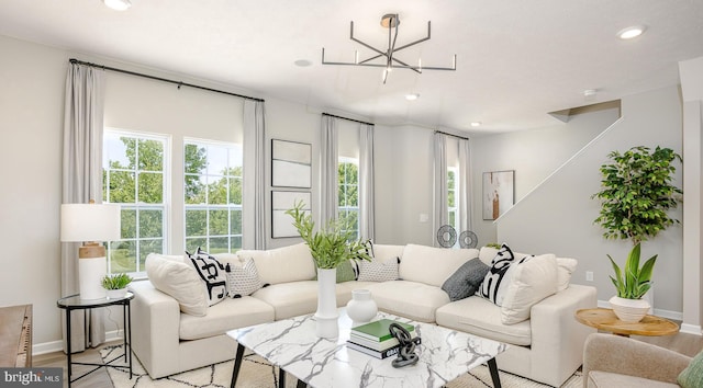 living room featuring light wood-type flooring and a notable chandelier