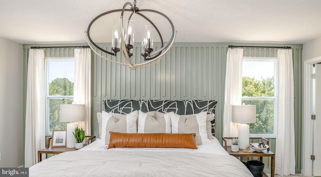 bedroom featuring a chandelier and multiple windows