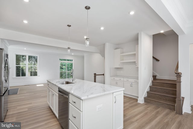 kitchen featuring a kitchen island with sink, appliances with stainless steel finishes, white cabinets, backsplash, and sink