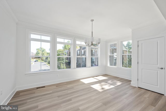 unfurnished dining area featuring a chandelier, light wood-type flooring, and ornamental molding