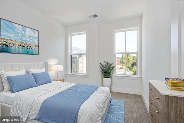 bedroom with light colored carpet and multiple windows