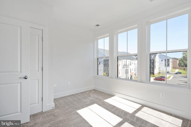 unfurnished room featuring light colored carpet