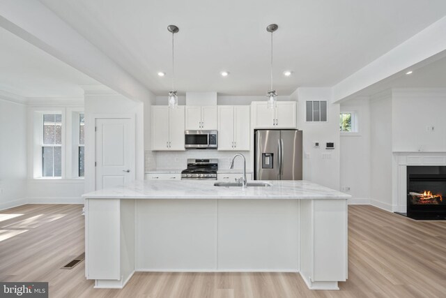 kitchen featuring sink, a large island, white cabinetry, hanging light fixtures, and appliances with stainless steel finishes