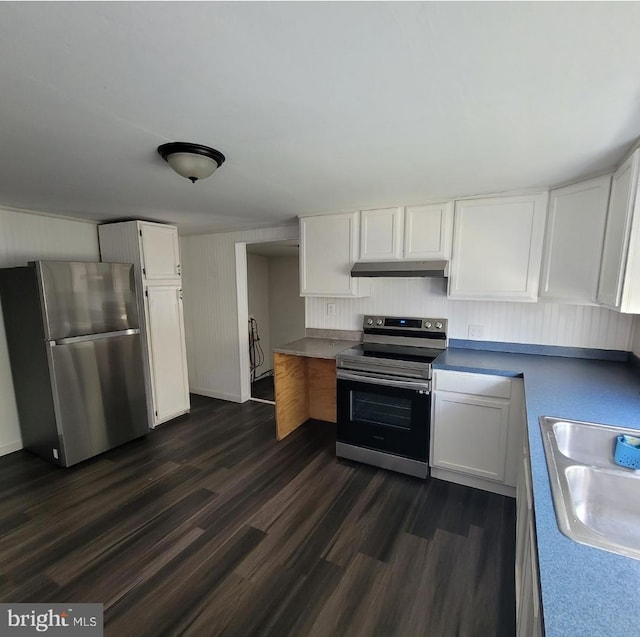 kitchen with appliances with stainless steel finishes, white cabinetry, dark wood-type flooring, and sink