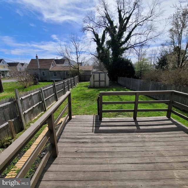 wooden deck featuring a lawn and a storage shed