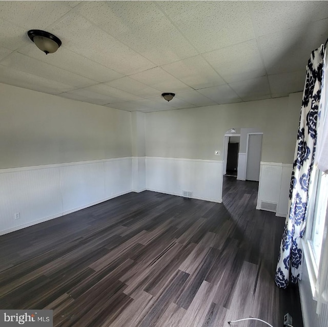 unfurnished room featuring a paneled ceiling and dark wood-type flooring