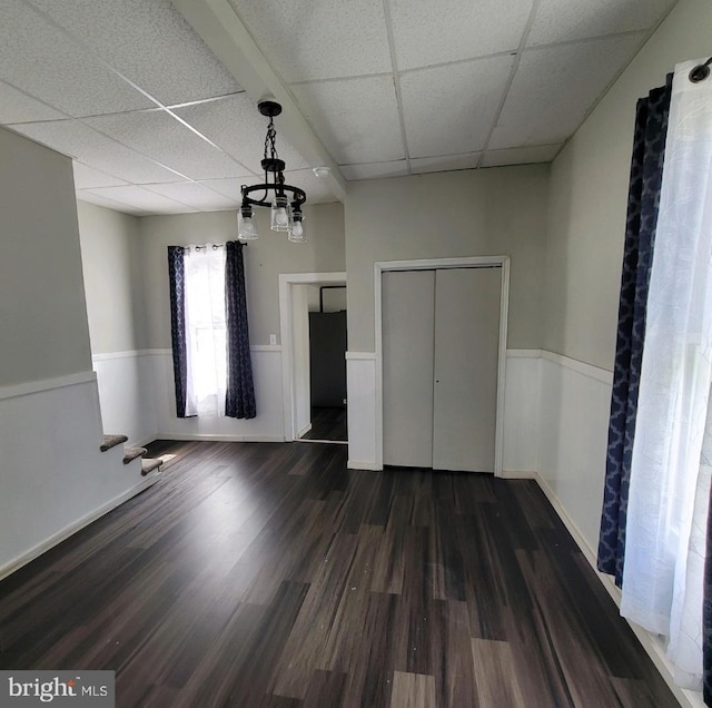 unfurnished bedroom with dark hardwood / wood-style floors and a drop ceiling