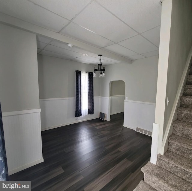 empty room featuring dark hardwood / wood-style floors and a drop ceiling