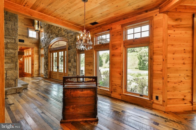 interior space with wood ceiling, wood walls, plenty of natural light, and dark wood-type flooring