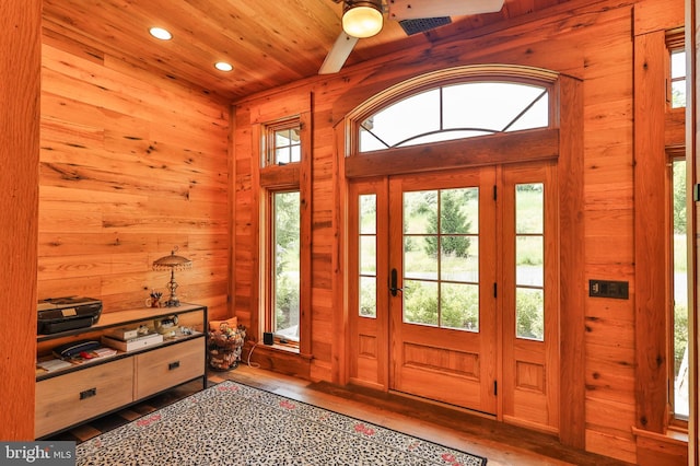 foyer with wooden walls, hardwood / wood-style floors, and a healthy amount of sunlight