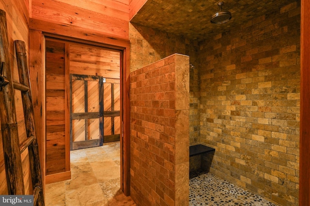 bathroom with wood walls and brick wall