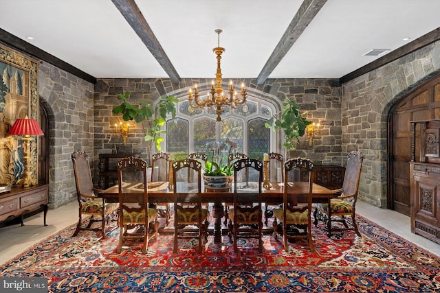 dining space featuring beamed ceiling, a notable chandelier, and a fireplace