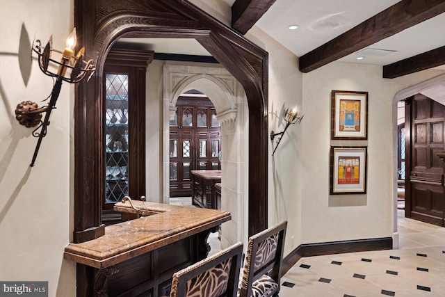 bar featuring beam ceiling and light tile patterned floors