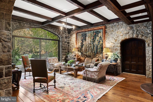 interior space featuring coffered ceiling, beamed ceiling, a notable chandelier, and hardwood / wood-style flooring