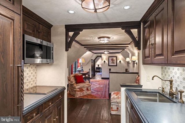 kitchen featuring dark brown cabinetry, dark wood-type flooring, and sink