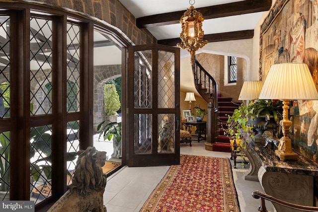 tiled foyer featuring lofted ceiling with beams