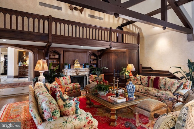 living room featuring beamed ceiling, wood-type flooring, high vaulted ceiling, and ceiling fan