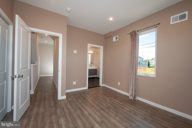 unfurnished bedroom with wood-type flooring and ensuite bathroom