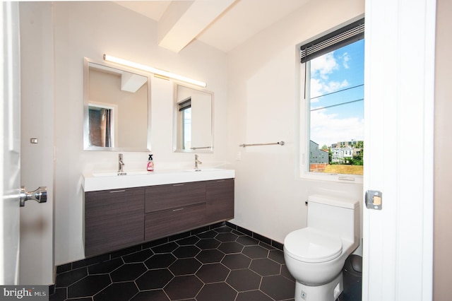 bathroom with tile patterned flooring, vanity, and toilet