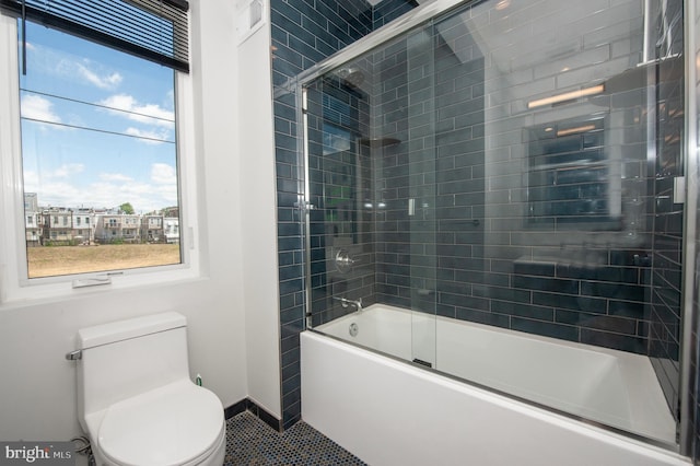 bathroom with shower / bath combination with glass door, tile patterned floors, and toilet