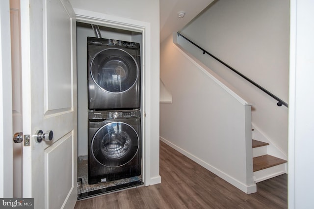 laundry area with stacked washer and clothes dryer and hardwood / wood-style flooring