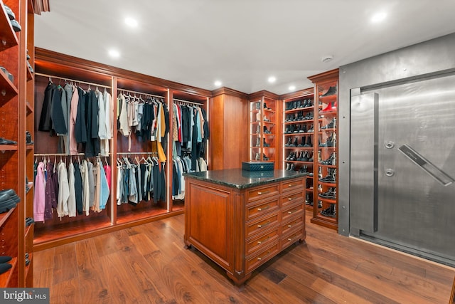 walk in closet with dark hardwood / wood-style flooring