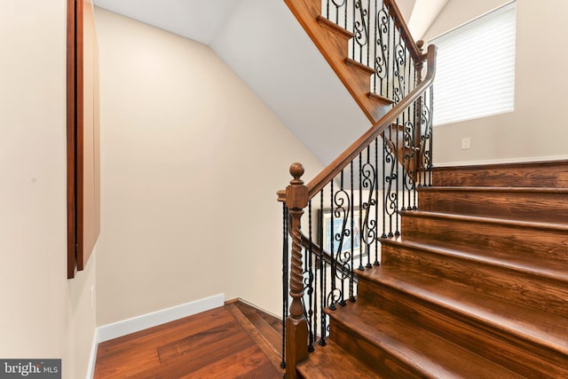 staircase with hardwood / wood-style flooring and vaulted ceiling