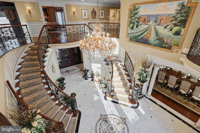 entrance foyer featuring a chandelier and ornamental molding