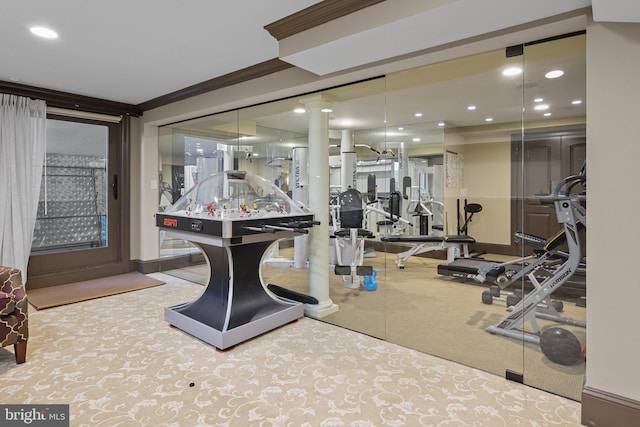 gym featuring light colored carpet and ornamental molding